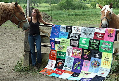 Milie with her high school graduation T-shirt quilt.  by Too Cool T-shirt Quilts