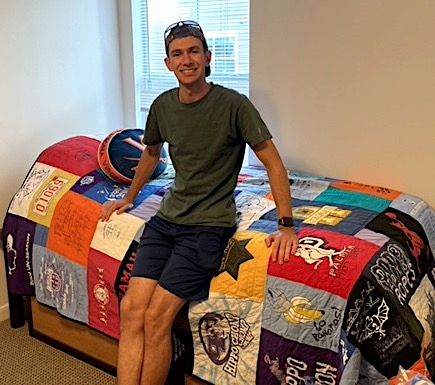 Sitting on a Too Cool T-shirt Quilt in a dorm room