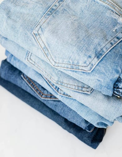 Stack of blue jeans waiting to be made into a quilt by Too Cool T-shirt Quilt 