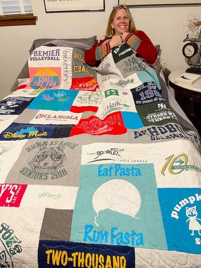 Woman under covers of a T-shirt quilt by Too cool T-shirt quilts