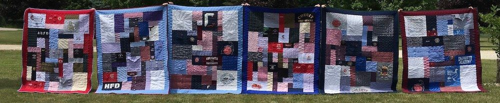 memorial quilts lined up made by Too Cool T-shirt Quilts